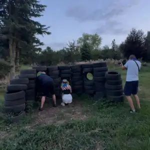 dwie osoby schowane za oponami, gra w paintball laserowy